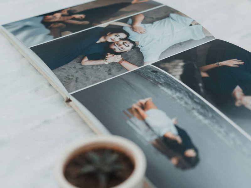 open holiday photo book with travel photos on a table